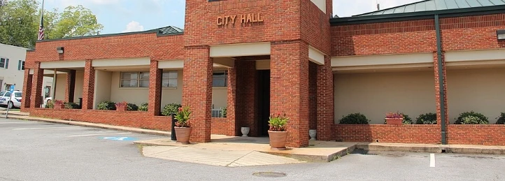 Austell City Hall brick building with front entrance and potted plants.