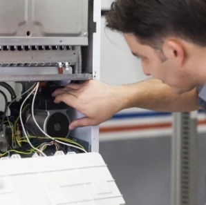 Technician inspecting electrical wiring inside an HVAC system.