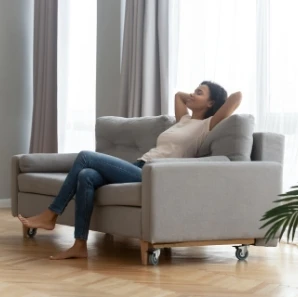 Woman relaxing comfortably on a living room sofa at home.